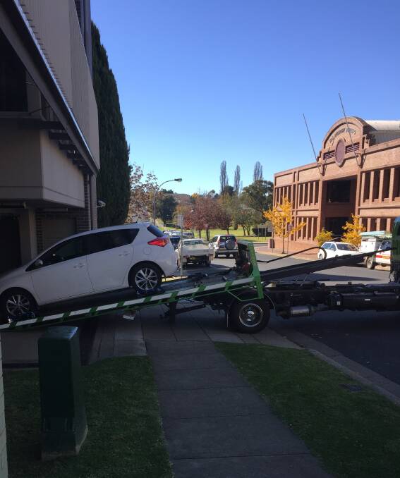 Seized: The stolen white Toyota Corolla is unloaded at Armidale Police Station where it will undergo forensic examination. It was dumped in Judith St on Wednesday.