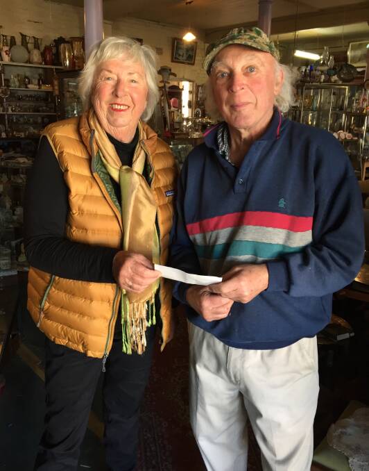 No bag lady: Cherie Pethard accepts a $200 cheque from Walcha Together president Chris Page in his Antique Junque shop on Monday. The money will be used to encourage the use of cloth shopping bags.