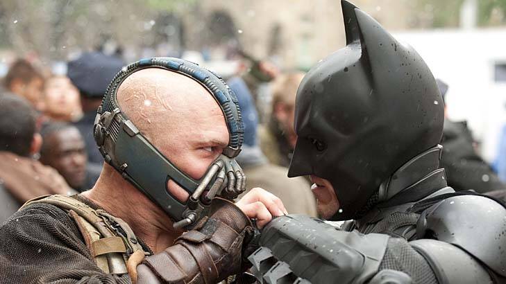 Tom Hardy as Bane and Christian Bale as Batman face off in <i>The Dark Knight Rises</i>.