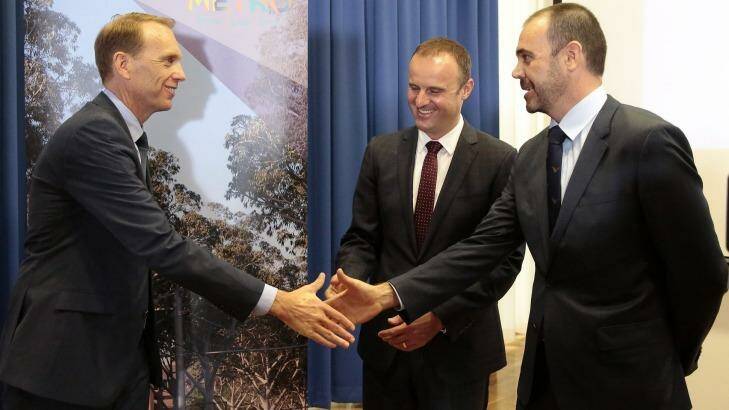 From left, ACT Deputy Chief Minister Simon Corbell, Chief Minister Andrew Barr and Canberra Metro Consortium chairman Mark Lynch shake hands as the winning tender is announced on February 1.   Photo: Jeffrey Chan