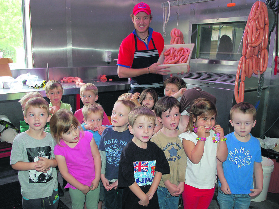 Walcha Preschool students learning about sausage making from butcher Jonathon Cross.