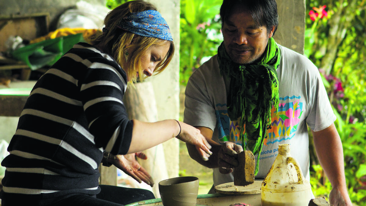 Gemma King and master potter and guardian of Ub Ubbo Exchange and full blooded Igorot, Lope Bosaing. Lope is instructing Gemma on potting practices at the Ub Ubbo Exchange headquarters in Sagada. Photo by Henry Garriock.
