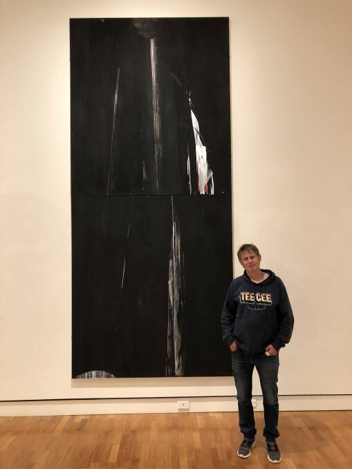 Walcha artist Angus Nivison in front of his works 'Light into Darkness #2 and #3