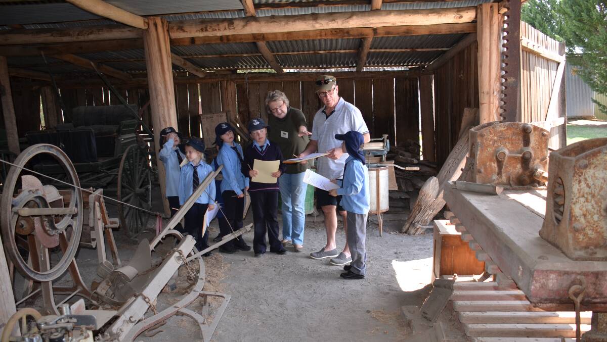 PRESERVING OUR HISTORY: Jane Morrison of the Walcha Historical Society showing children around the dilapidated machinery shed in 2018