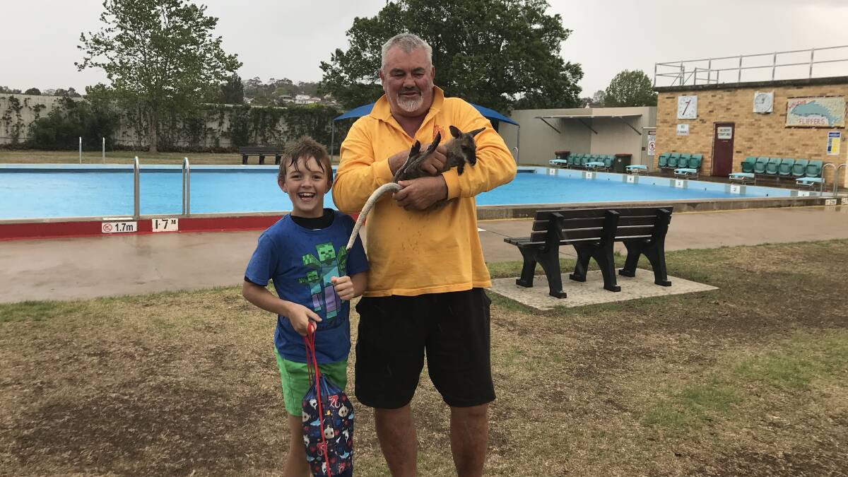 HOPPING IN THE RAIN: Andrew Cross encounters a 10-month-old Yarrowitch local with Blaine Cooney at the Walcha Pool on Saturday.