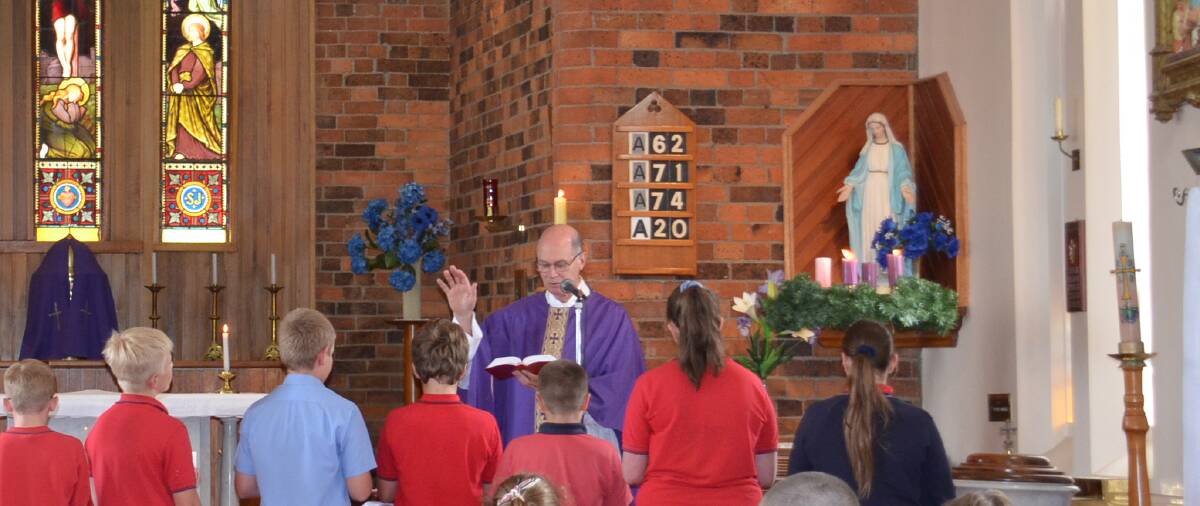 Monsignor Ted Wilkes conducts the year 6 farewell mass at St Patrick's Primary School in Walcha