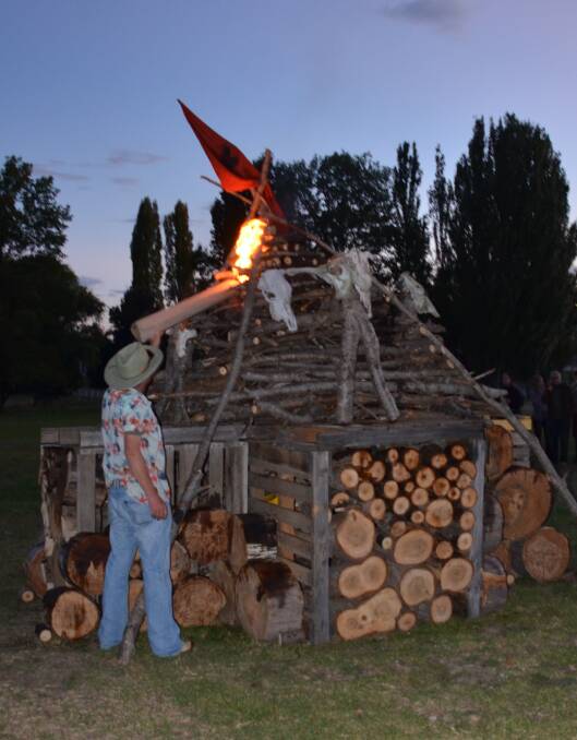 BURN BABY BURN: Kit Dawson puts a flame to his sculptural bonfire during the festival.