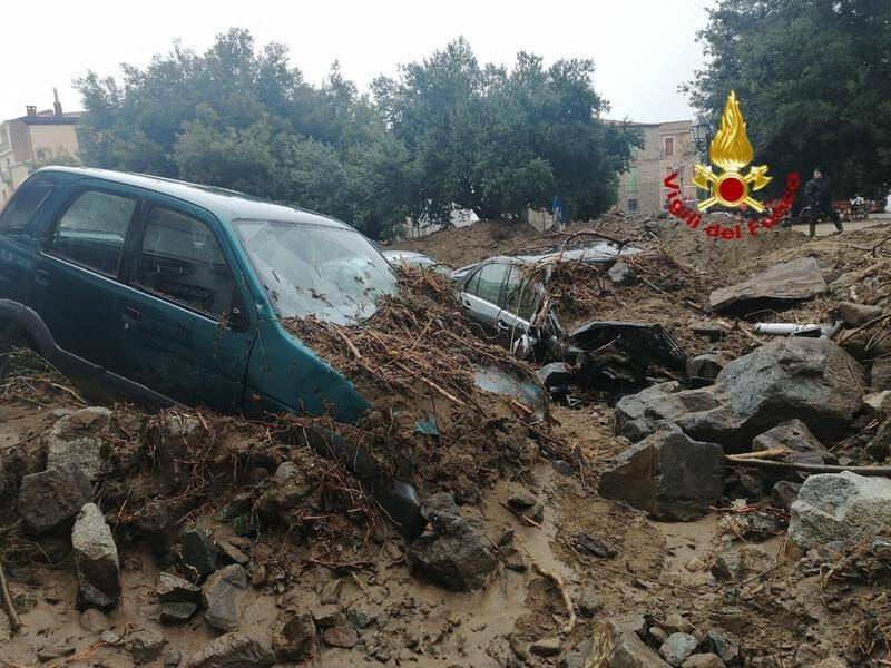 Cars and debris litter a street in the Sardinian town of Bitti after it was hit by a huge mudslide.